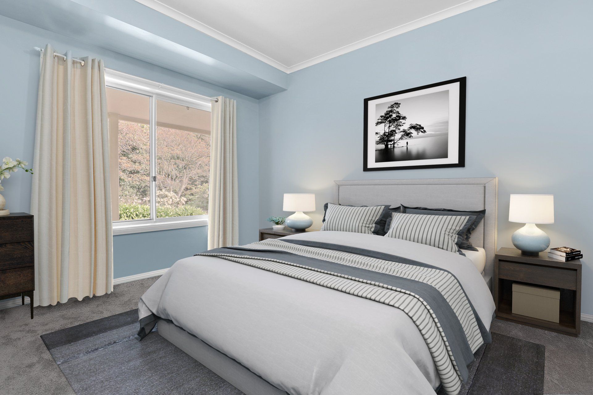 Neat bedroom with a gray bed, matching nightstands, and a large window with beige curtains