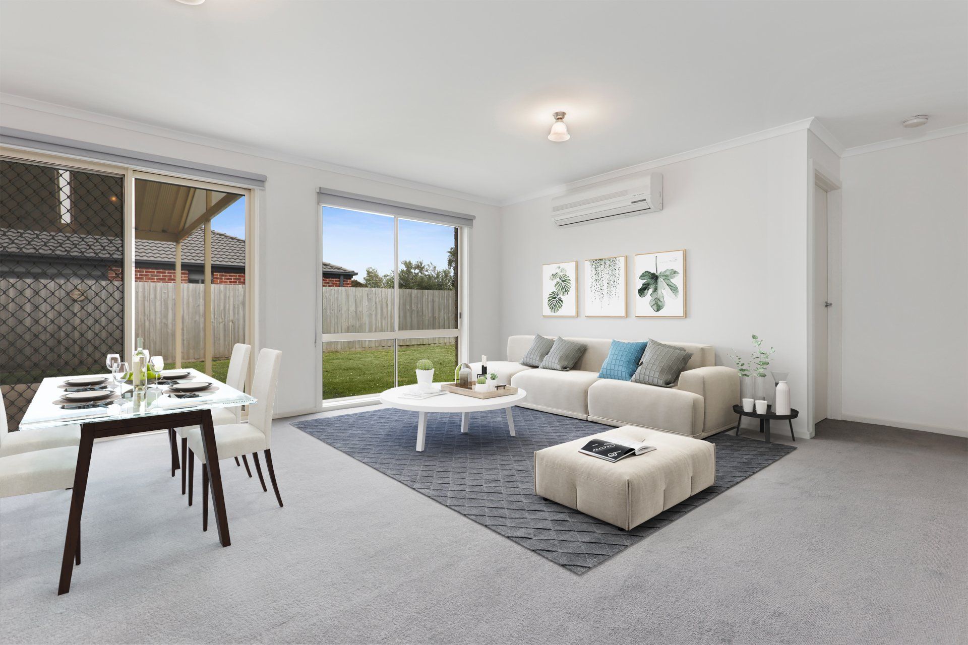 Bright modern living room with gray sofa, white armchair, dining table, and sliding doors to a patio.