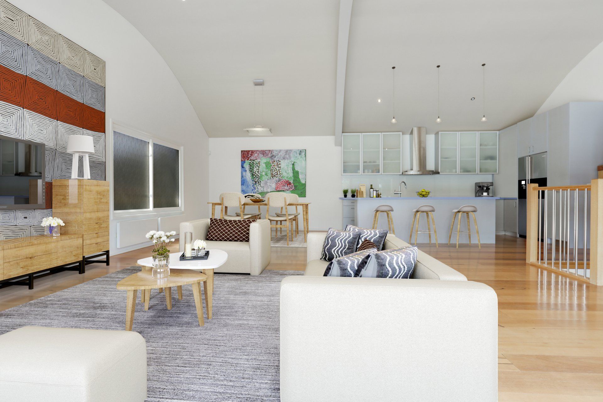 Bright open-concept living room with gray sofa, rug, and modern kitchen in the background.