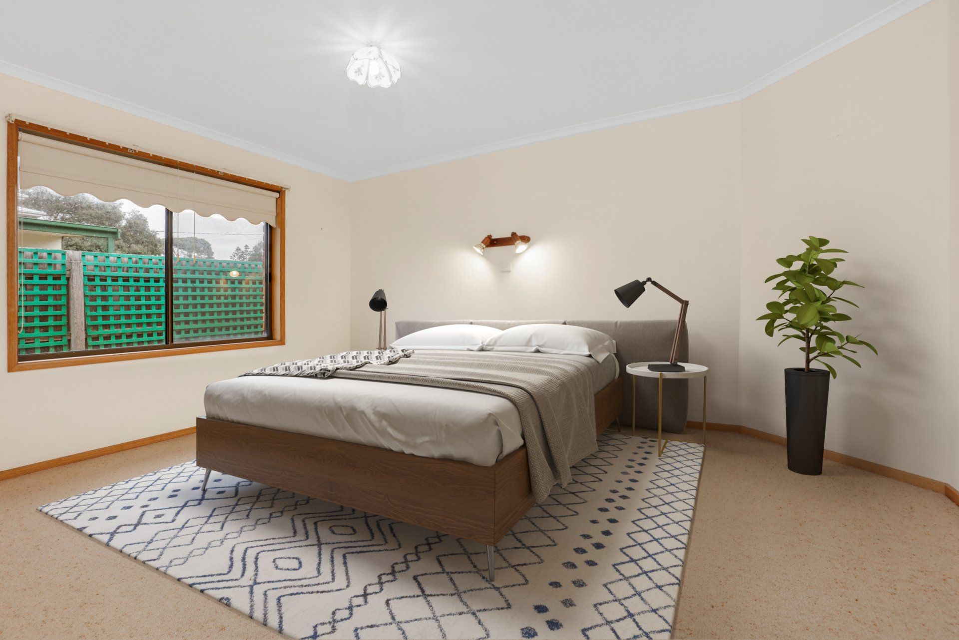 Bright bedroom with a made bed, bedside lamps, window, and potted plant on a rug.