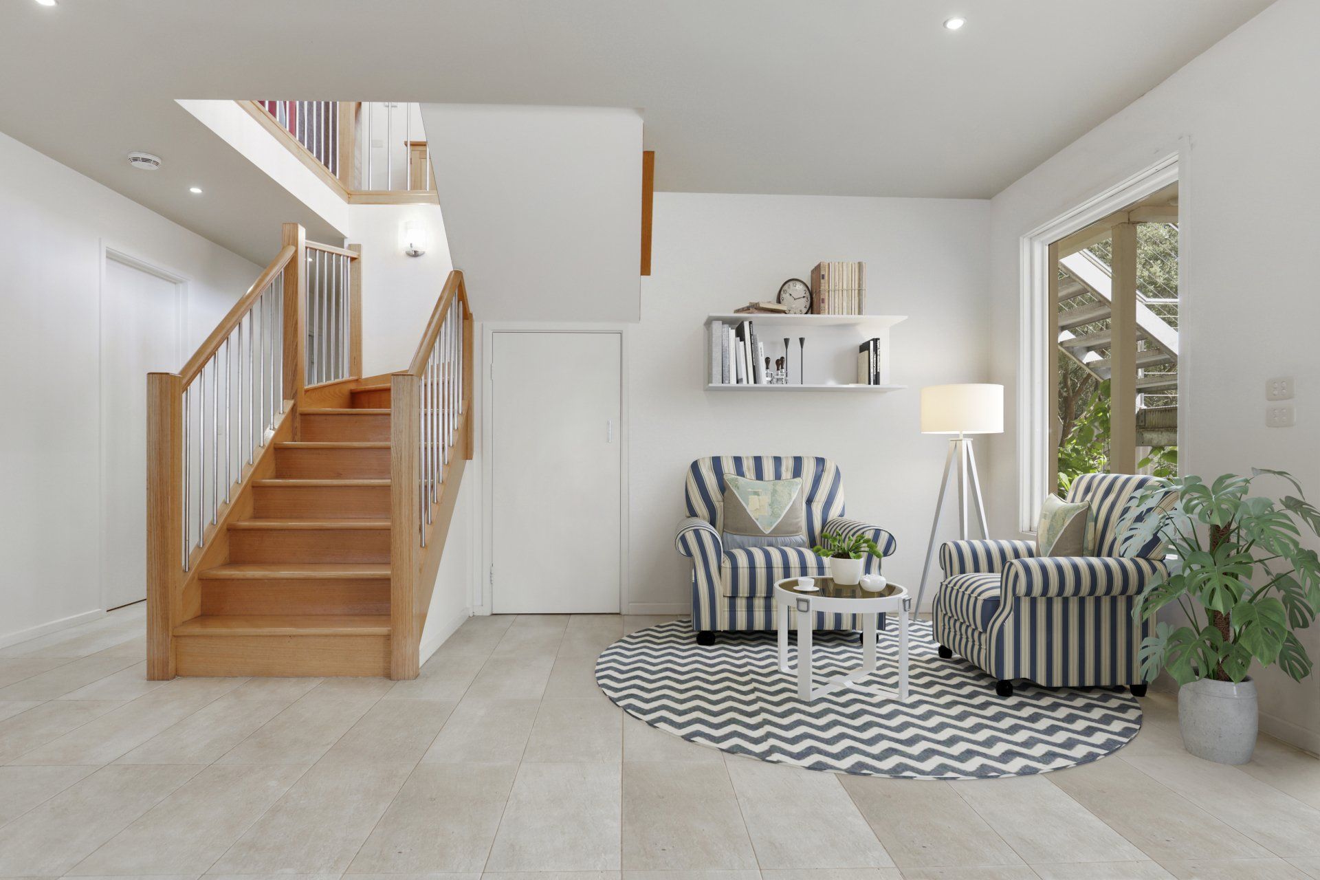Bright modern living room with wooden stairs, striped armchairs, lamp, and potted plants