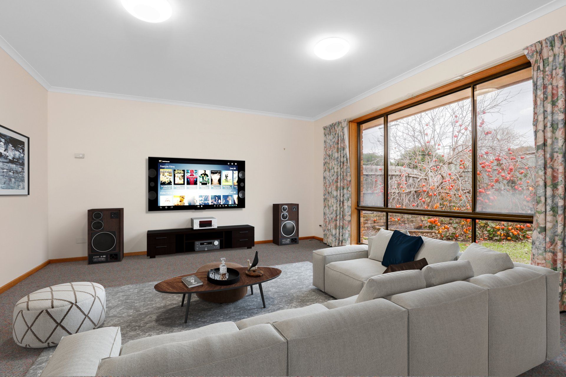 Modern living room with a sectional sofa, wall-mounted TV, speakers, coffee table, and large window.