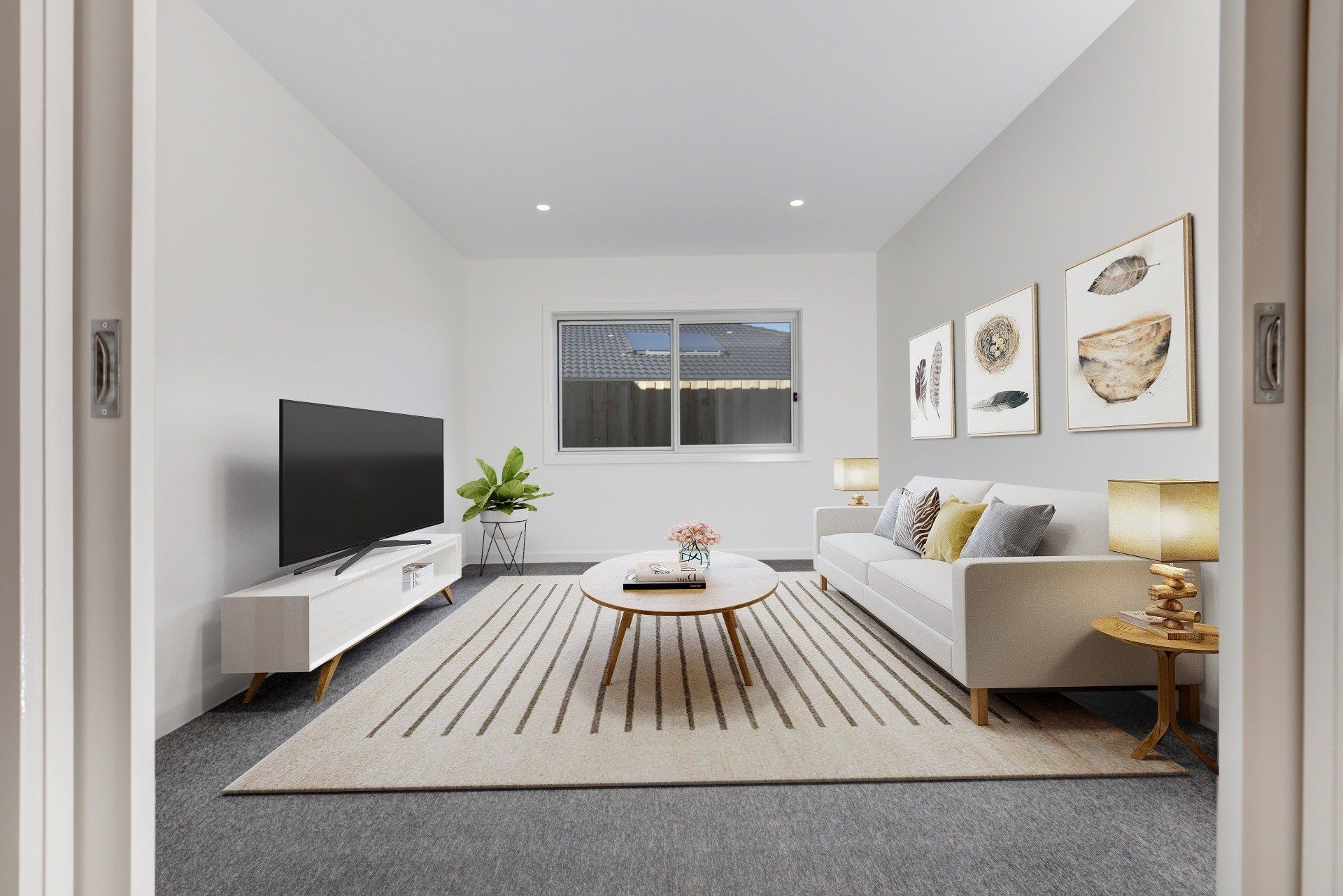 Bright modern living room with a gray sofa, TV, coffee table, rug, and wall art