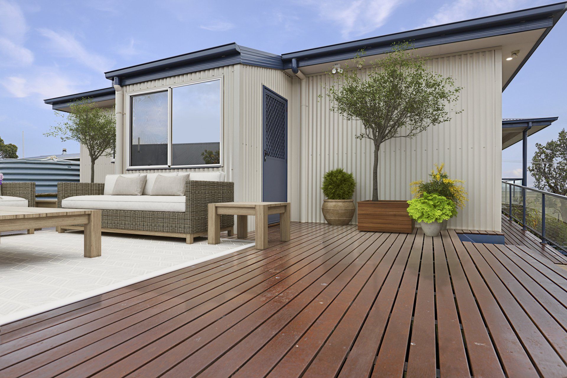 Modern house deck with wooden flooring, patio sofa, potted plants, and sliding glass door