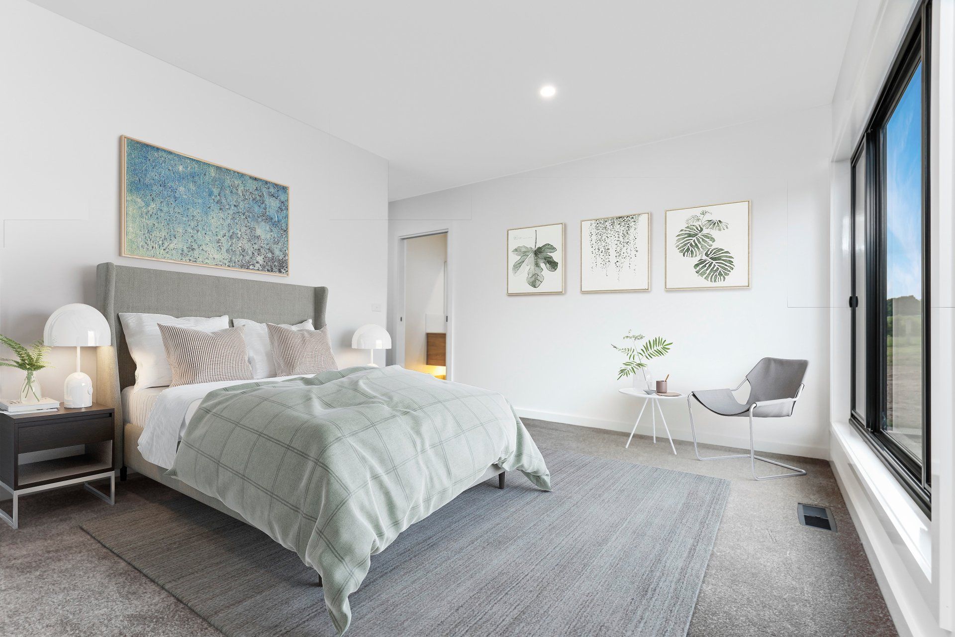 Bright modern bedroom with a large bed, gray carpet, wall art, and big windows overlooking the room