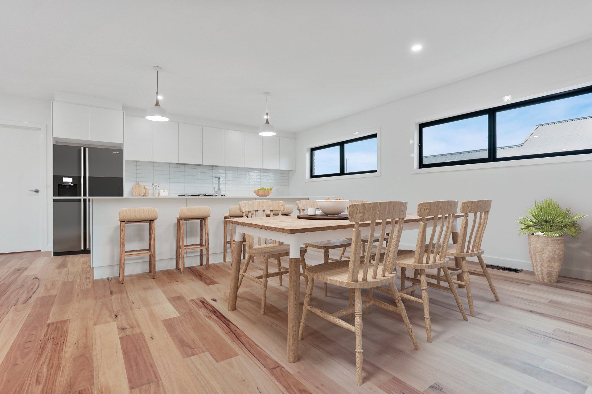 Bright modern dining room and kitchen with wooden table, chairs, light wood floors, and large windows