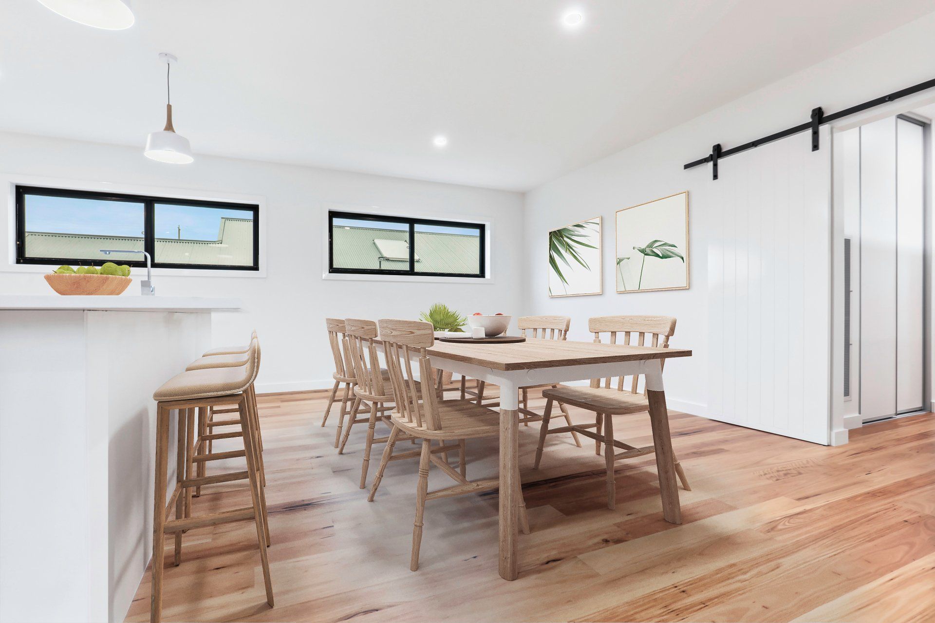 Bright dining room with wooden table, chairs, bar stools, white walls, and large windows.