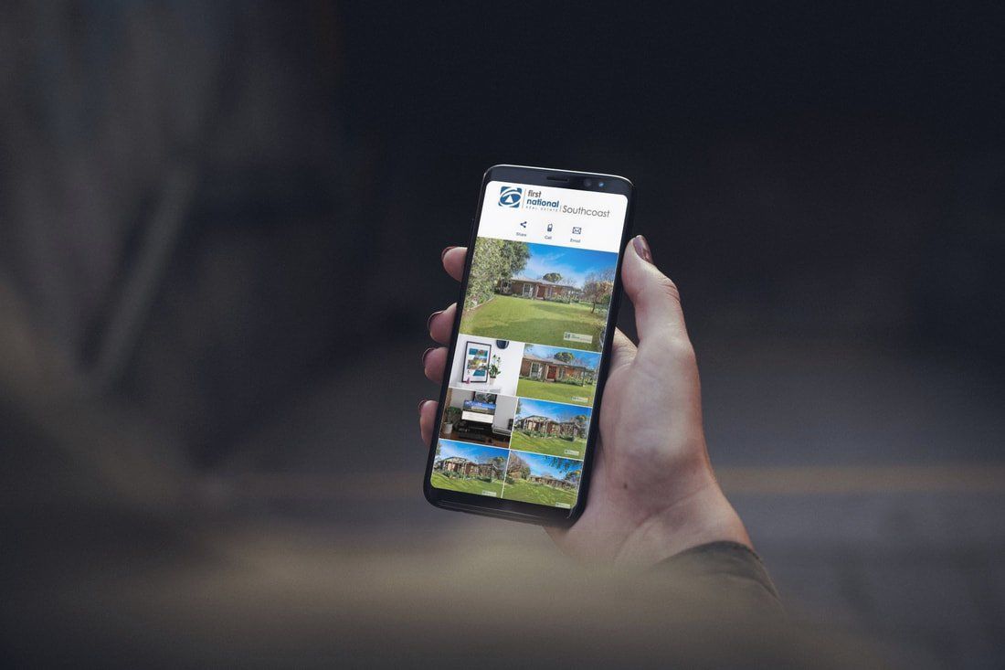 Hand holding a smartphone showing a social media feed outdoors