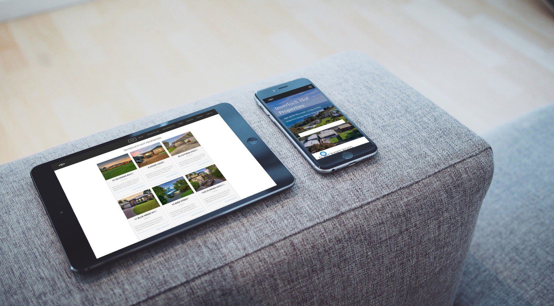 Tablet and smartphone on a gray ottoman displaying websites