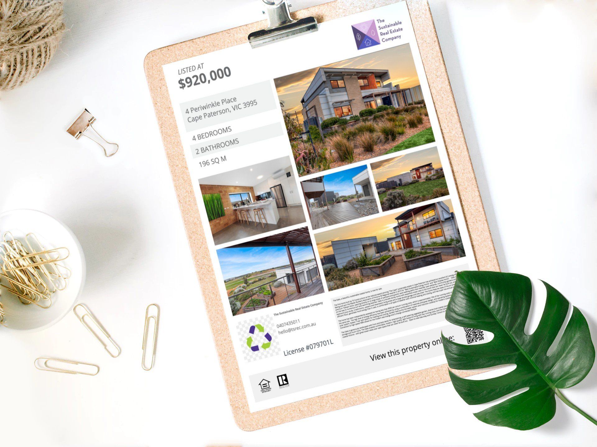 Real estate listing on clipboard with house photos, price, and green leaf on white desk