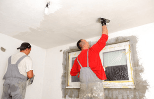When you need someone to plaster walls at your home in Northamptonshire call 01933 421 340 Plasterers working on a ceiling