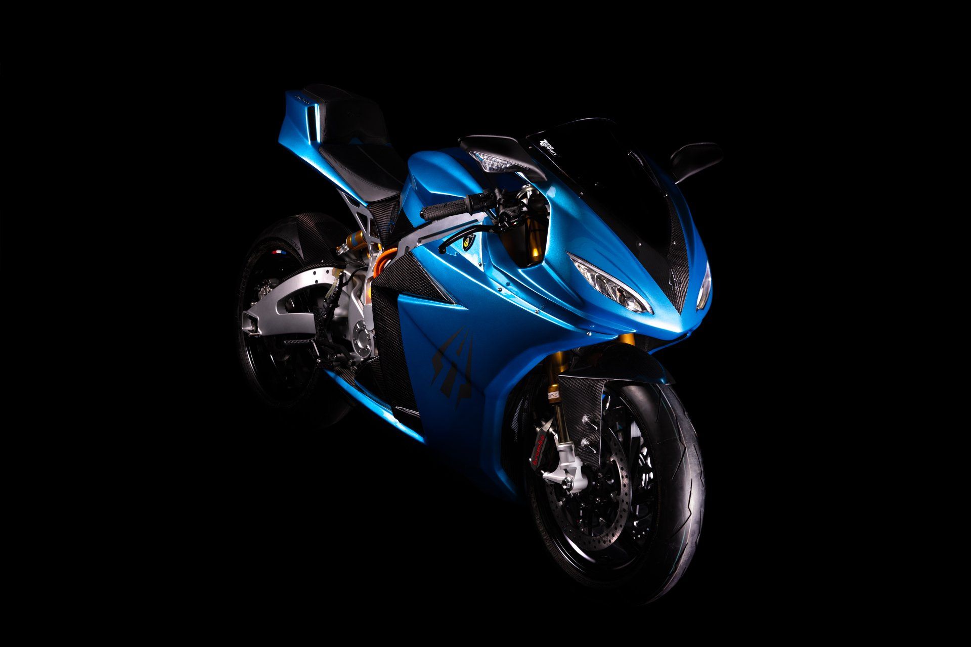 Blue electric motorcycle on a black background, angled view.