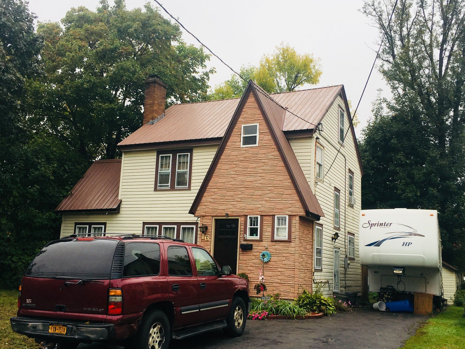 A red suv is parked in front of a house