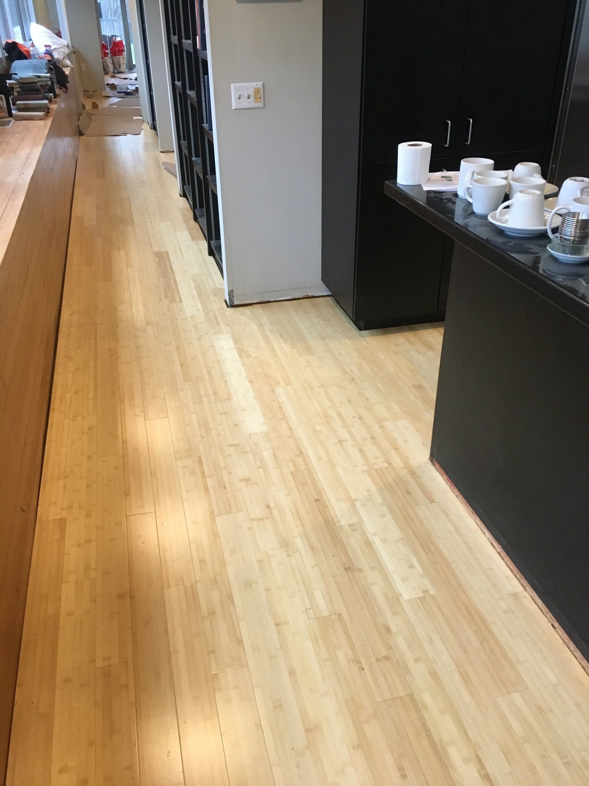 Wooden hallway beside a counter with cups and coffee supplies in an office break area
