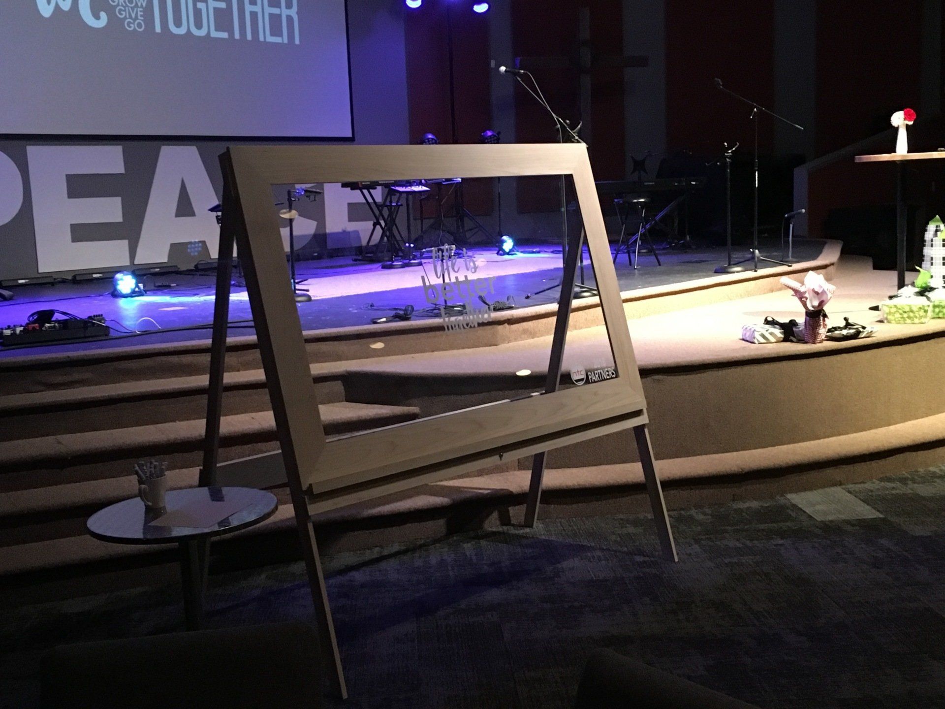 Stage with purple lighting and large framed sign in front of a podium