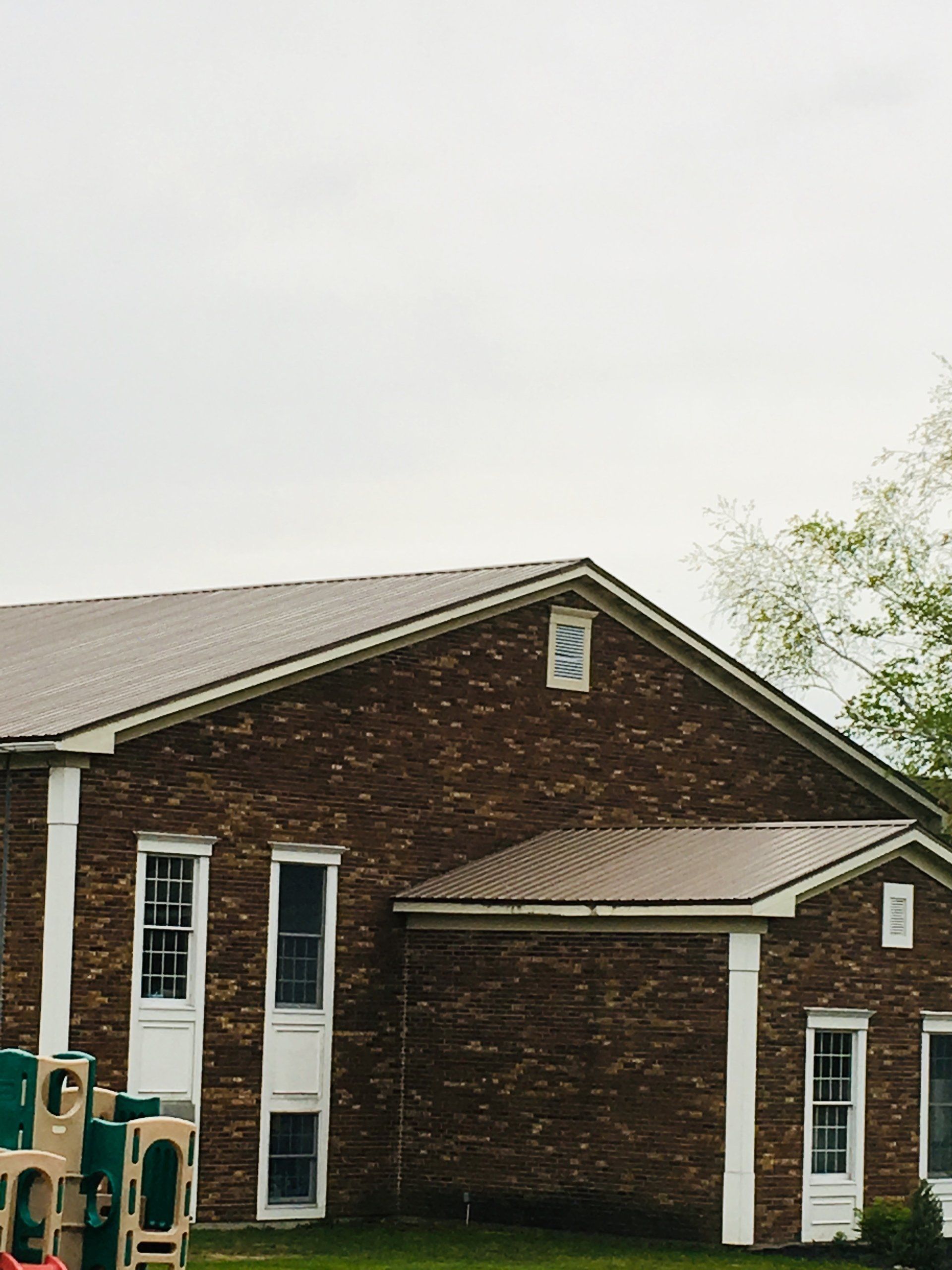 A brick house with a playground in front of it