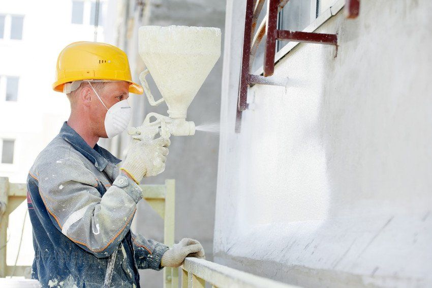 Plasterer facade builder worker with level at thermal insulation works