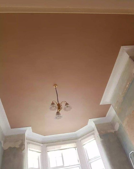 Smooth fresh plaster on a bay-window ceiling with decorative coving