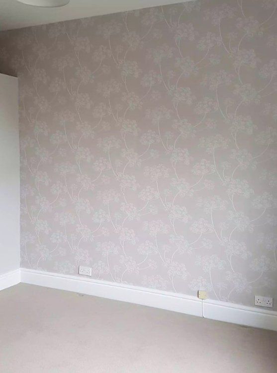 Light grey floral wallpaper feature wall with white skirting in a York home