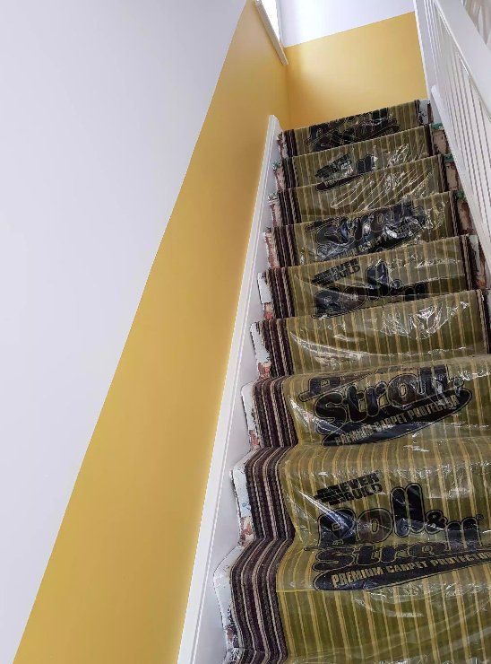 Mustard-yellow staircase walls protected during decorating in York