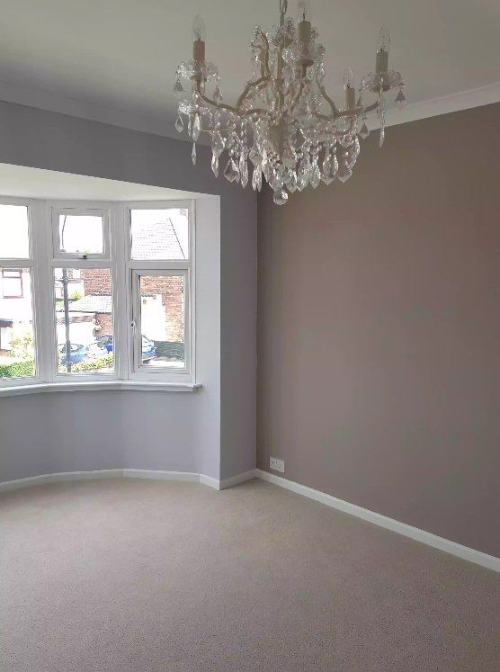 Grey and pink bedroom with bay window and chandelier in York