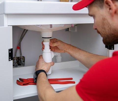 Plumber Installing Sink Siphon in Bathroom — Oakland County — Eric Fitzpatrick Plumbing