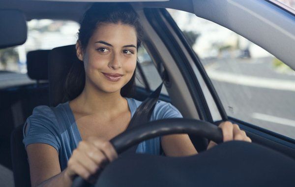 Smiling woman driving car