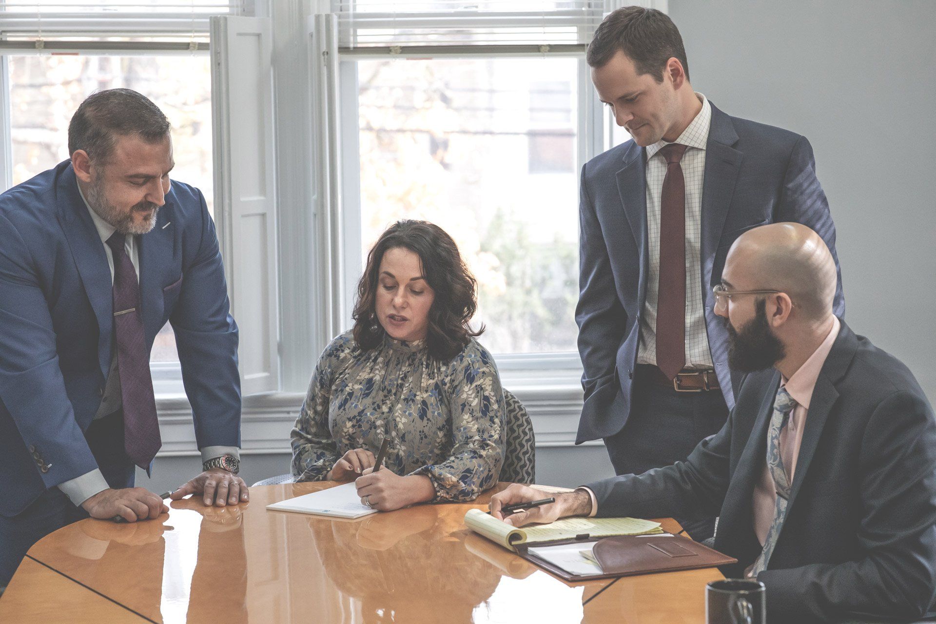 A group of business people are sitting around a table having a meeting.