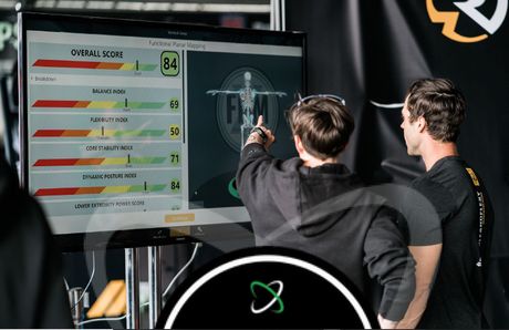 Two people review a large screen showing game stats at an esports event