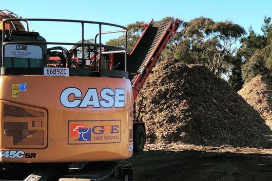 mulch excavator in front of pile of mulch