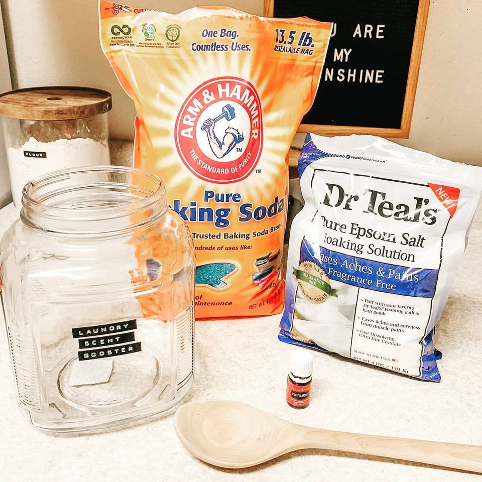 Mason jar, jars and bags of baking ingredients with a small spoon on a countertop