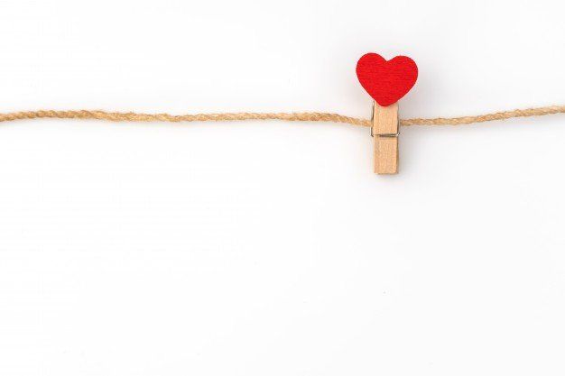 Red heart clipped to a twine string on a white background
