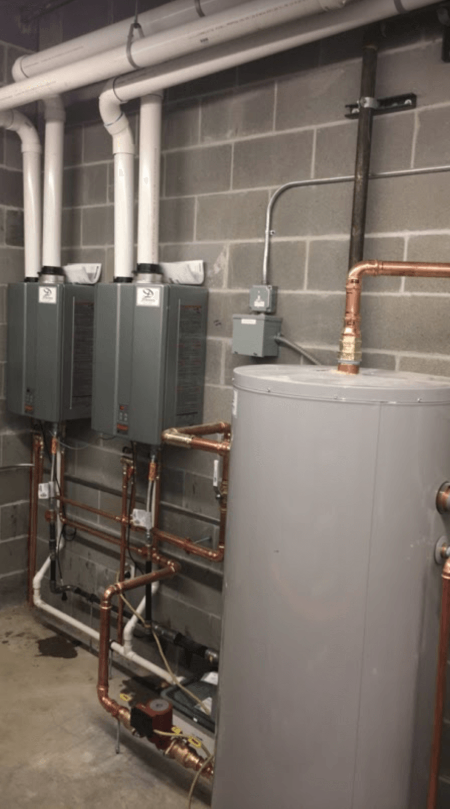 A room with a lot of pipes and a water heater.