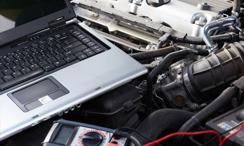 laptop on a open vehicle engine