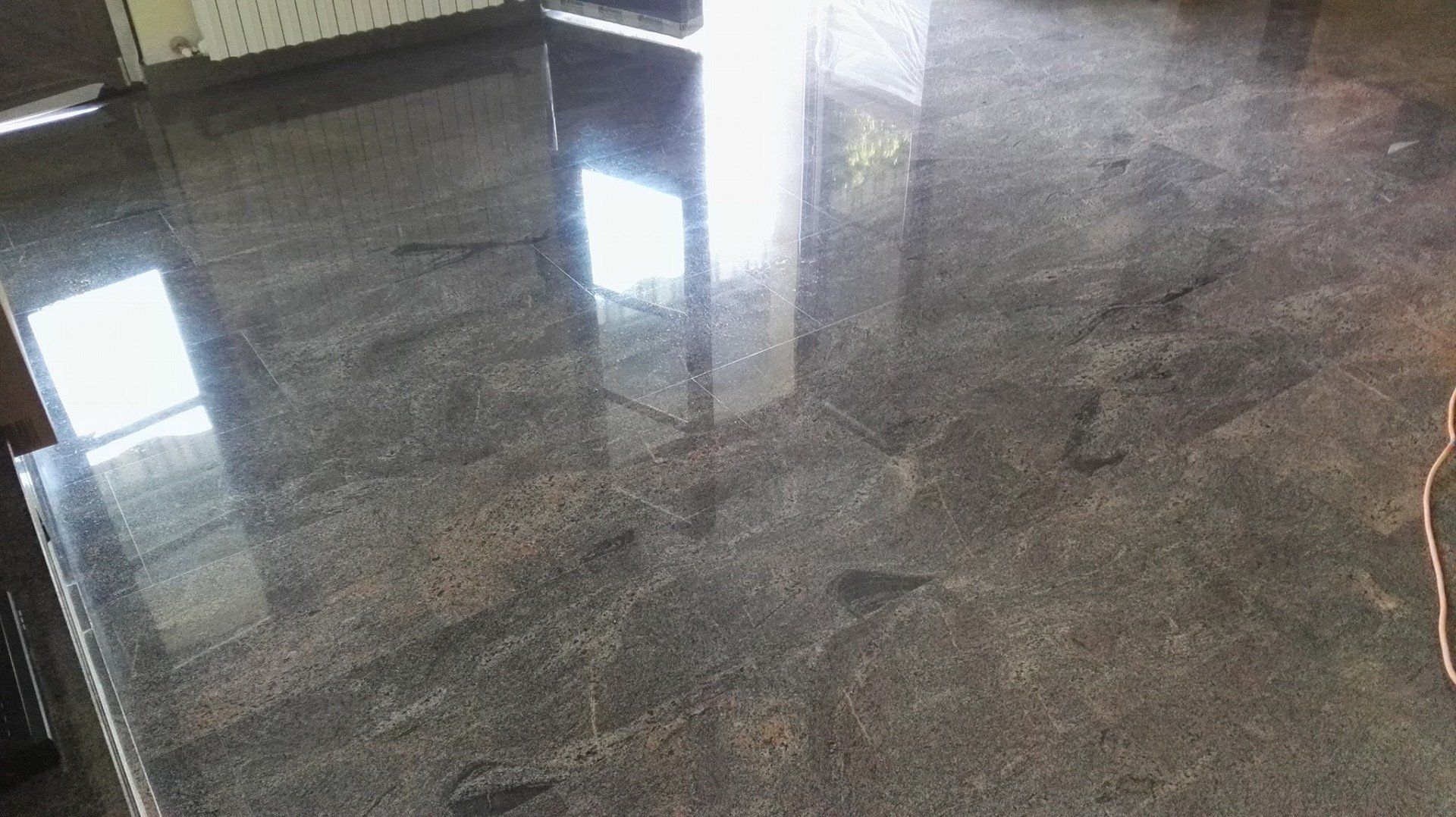 Polished dark granite countertop reflecting sunlight.