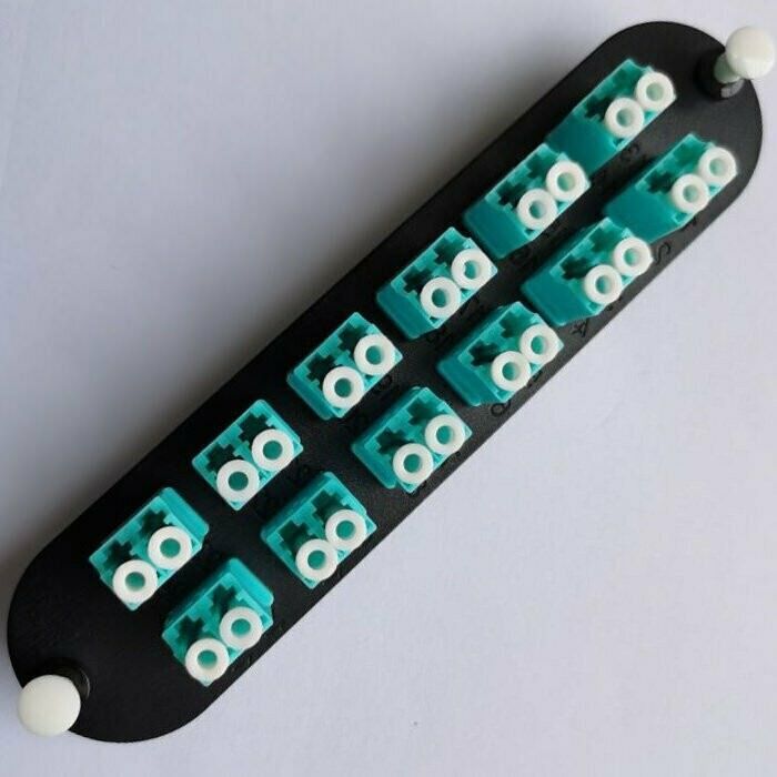 A row of green and white connectors on a black plate
