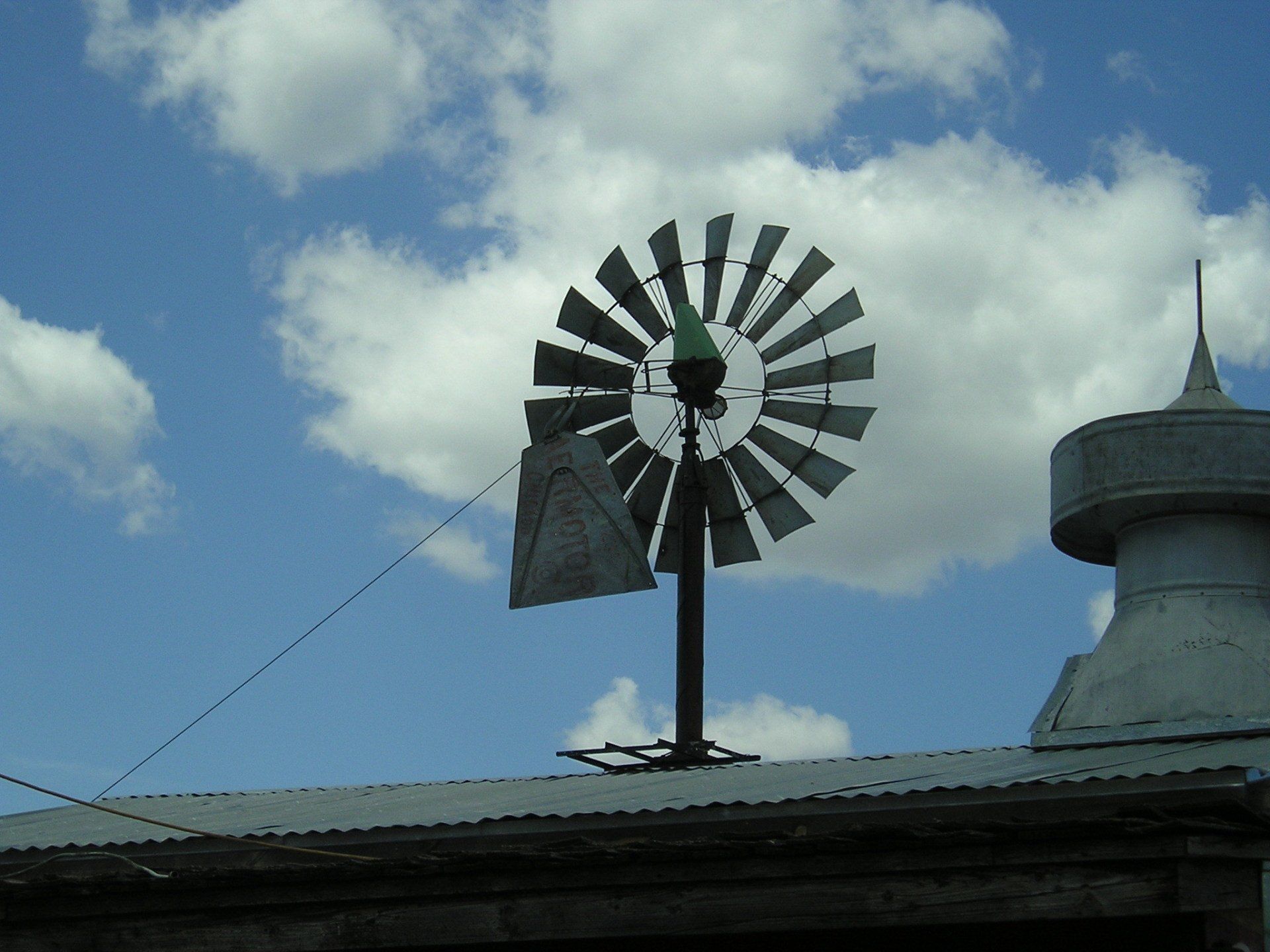 A windmill on top of a building with a blue sky in the background