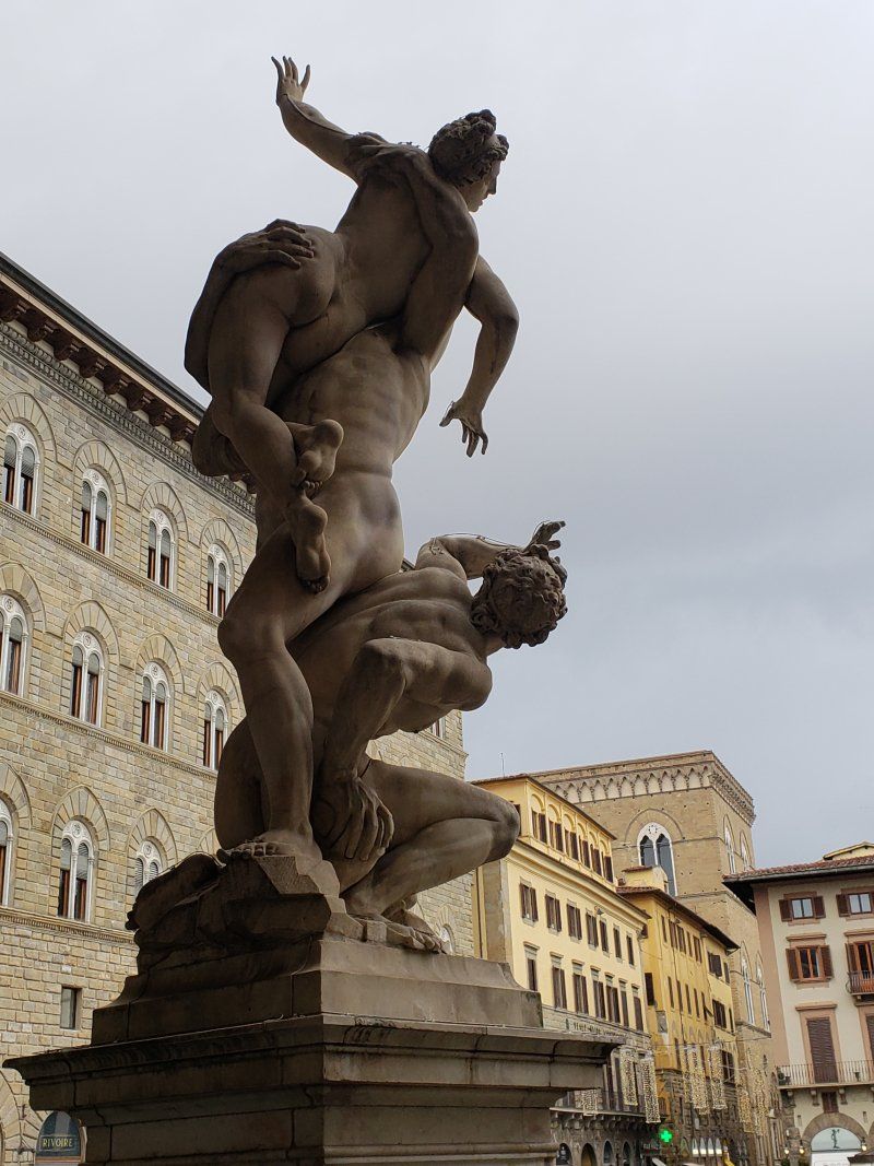 A statue of a man and a woman in front of a building