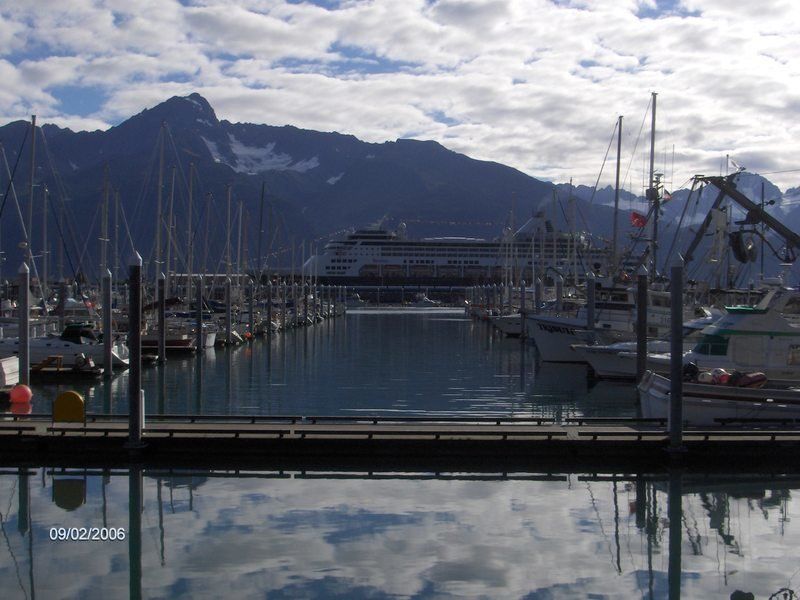 A boat is docked in a harbor with mountains in the background