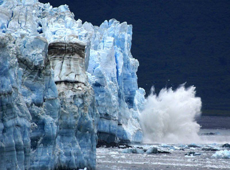 A large iceberg is breaking into the ocean.