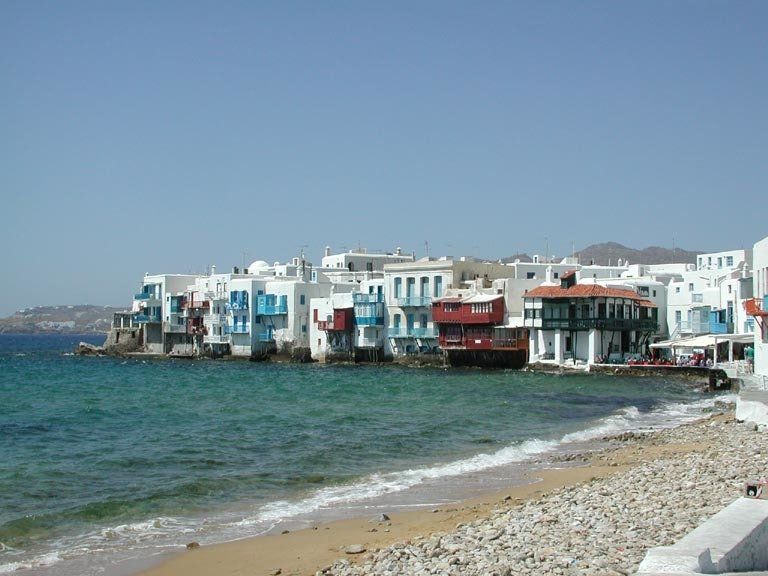 A row of buildings on the shore of a body of water