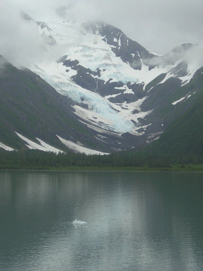 A mountain covered in snow is reflected in a lake