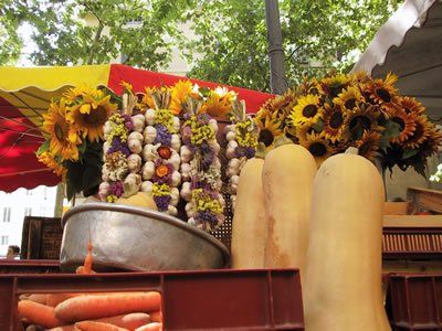 A bunch of vegetables and flowers are on display at a market