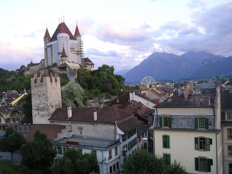 A castle sits on top of a hill overlooking a city