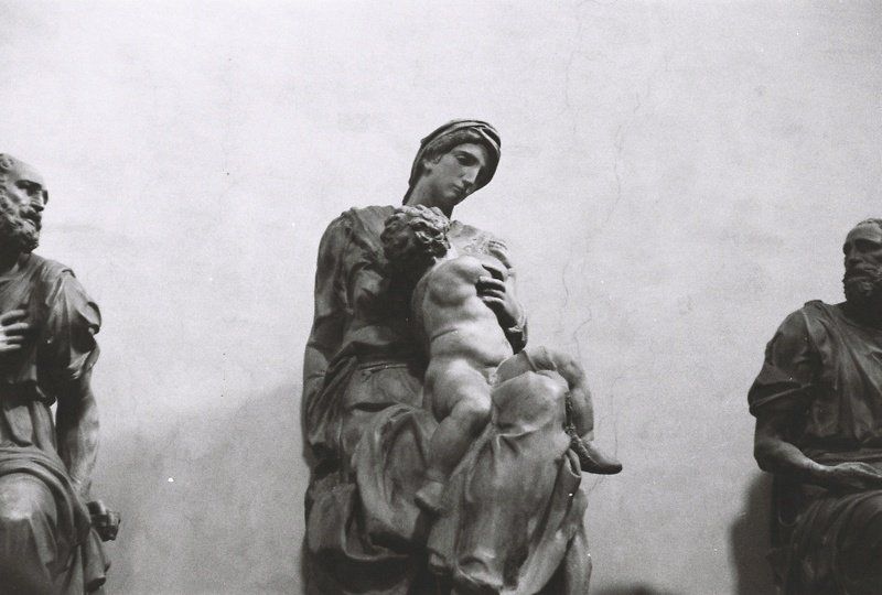 A black and white photo of a statue of a woman holding a baby