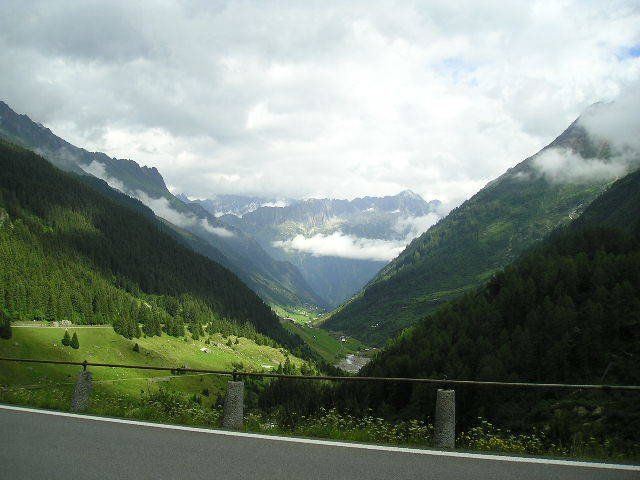 A road going through a valley with mountains in the background