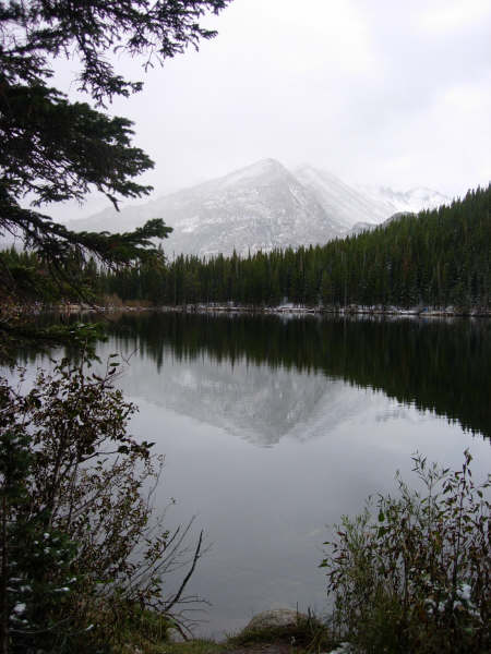 A mountain is reflected in a lake surrounded by trees