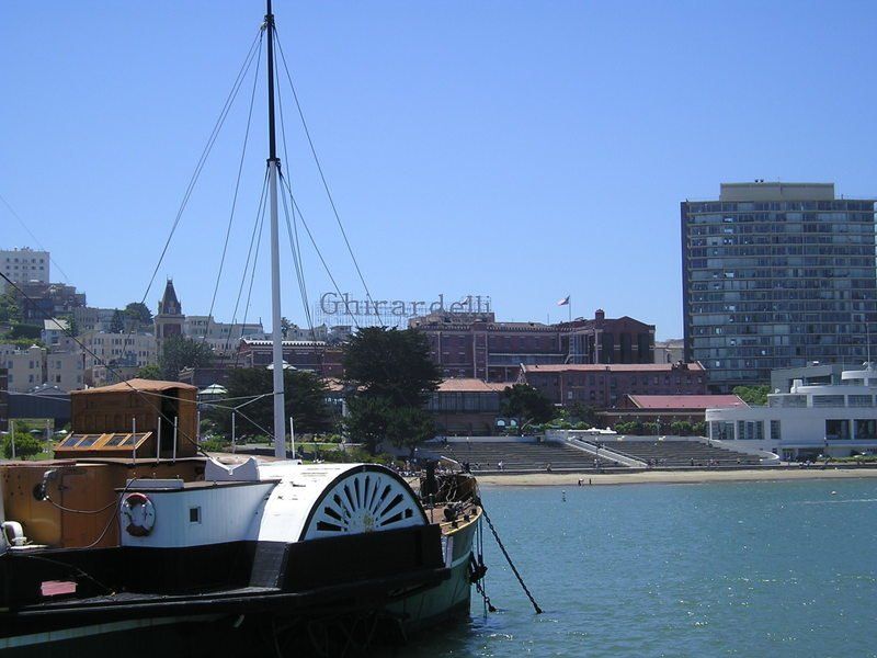 A boat is docked in front of a building that says ghirardelli