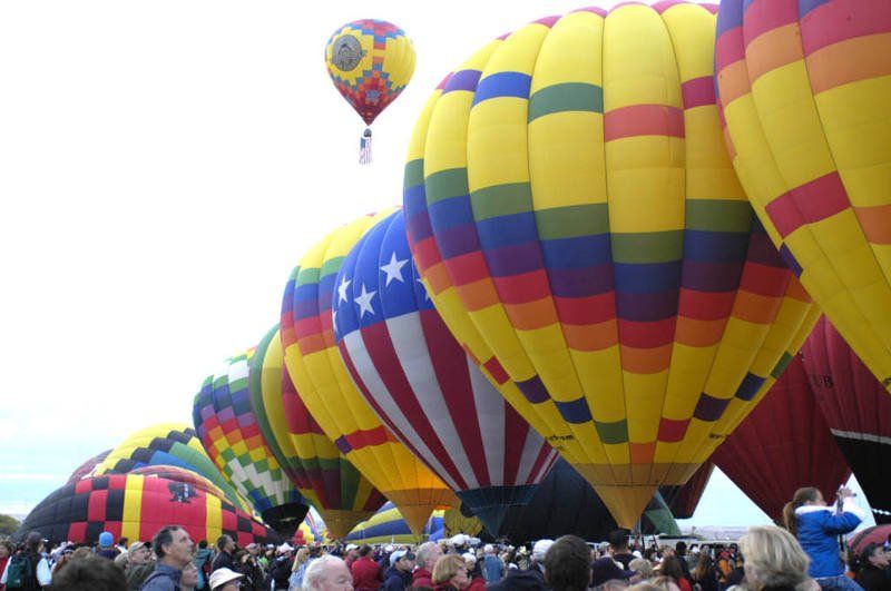 A bunch of hot air balloons are lined up in a row