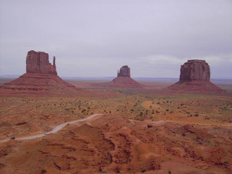 A desert landscape with three rock formations in the distance